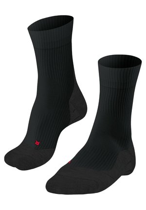 Calze nere a coste con punta e tallone rinforzati, che presentano un piccolo logo rosso. Il design si concentra su durata e comfort.