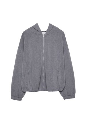 Haut à capuche zippé gris fabriqué en tissu doux, avec un corps large, des manches surdimensionnées et une capuche avec cordon de serrage. Aucun motif ni accent visible.