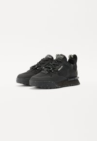 Schwarze Sneakers mit einer strukturierten Oberseite mit Mesh-Einsätzen, runder Zehenpartie, Gummisohle mit sprenkelnden Akzenten und Logo-Detail auf der Zunge.