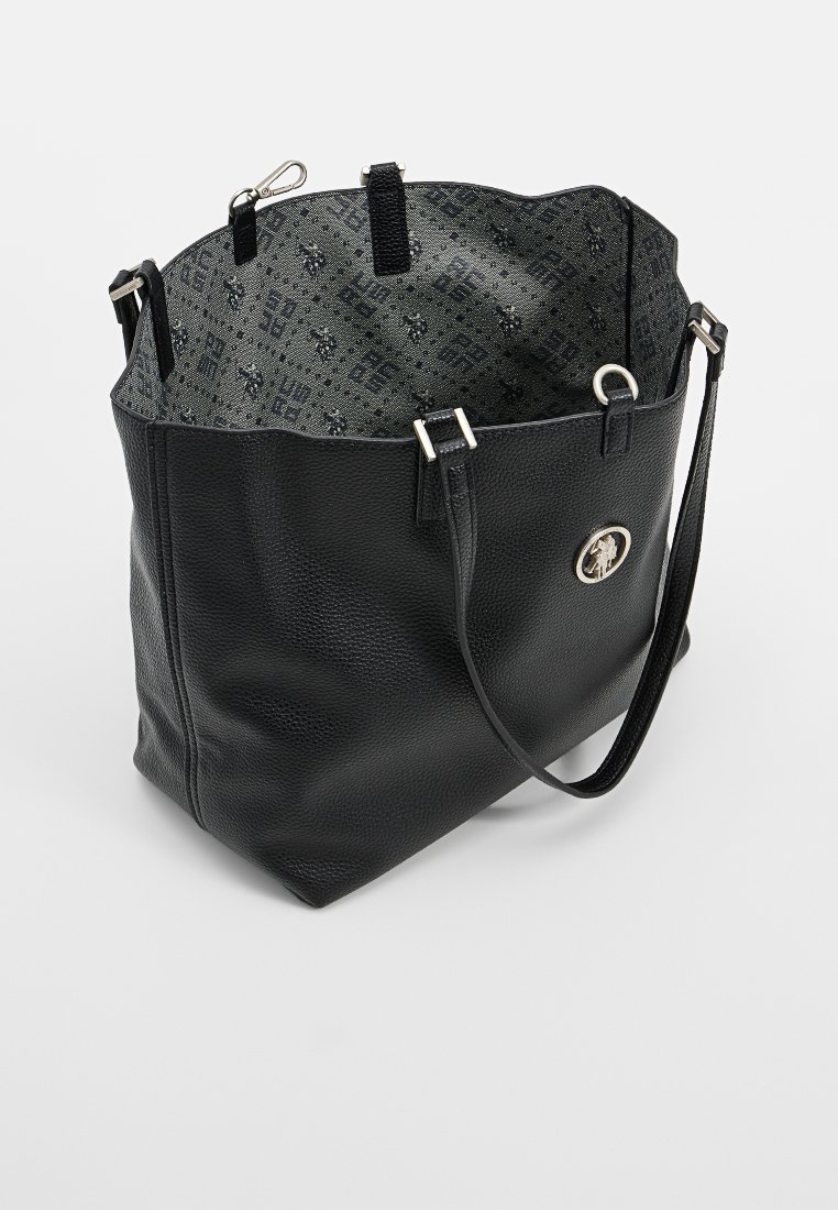 Bolso tote de cuero negro con correa de hombro ajustable, emblema circular en plata y forro interior de tela con patrón.