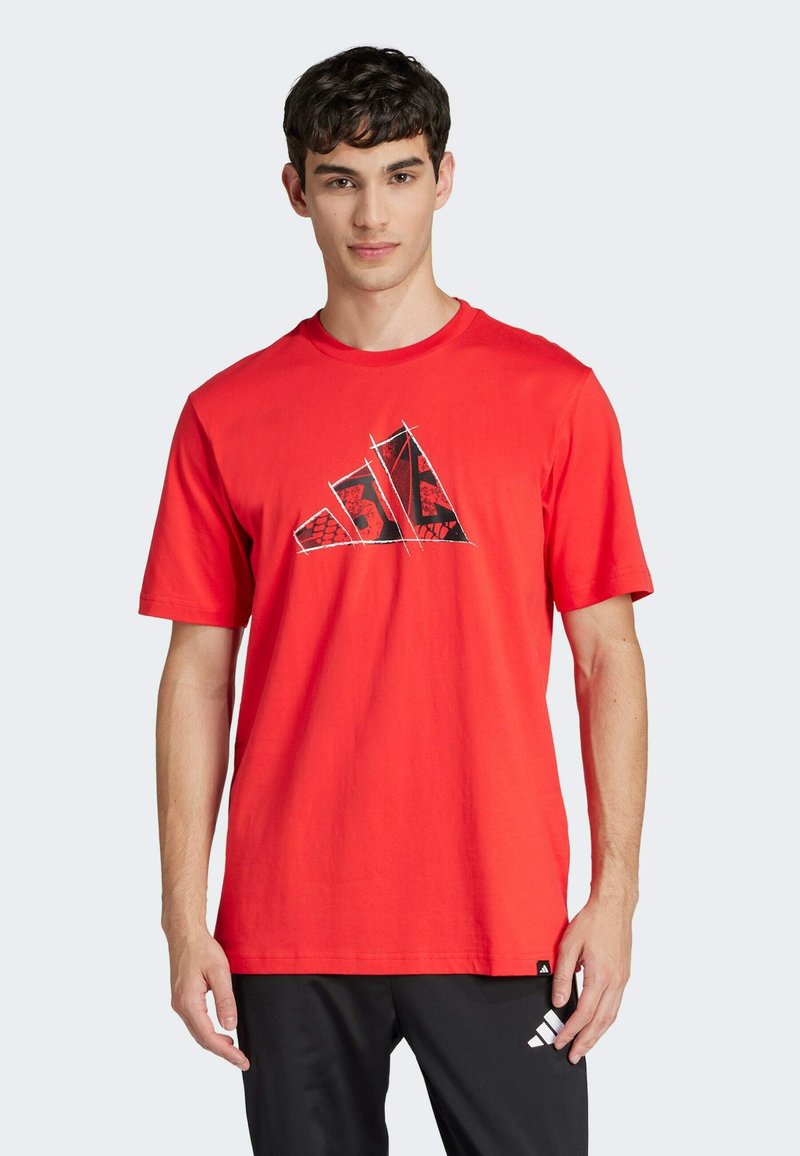 T-shirt di cotone rosso con maniche corte. Presenta un logo grafico nero e rosso sul fronte. Vestibilità casual con scollatura a girocollo.