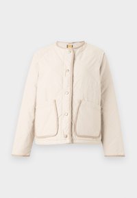 Beige quiltad jacka med rund halsringning, tryckknappar och två framfickor. Har ljusa bruna detaljer och en mjuk textur.