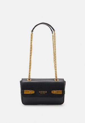 Sac à main en simili cuir noir avec une bandoulière en chaîne dorée, comportant deux accents en métal doré et un logo en relief à l'avant. Forme rectangulaire compacte.