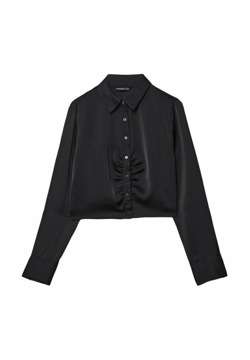 Blouse noire courte avec un col, fermeture à boutons sur le devant et détails froncés à la taille. Manches longues avec poignets à boutons. Tissu lisse.