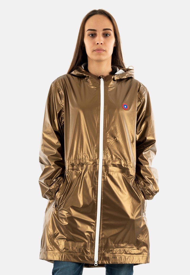 Imperméable brillant de couleur or avec capuche, fermeture éclair à l'avant, poches latérales et poignets élastiques. Présente un petit logo sur la poitrine.