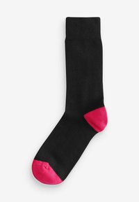 Sort sok med ribbet manchet; har pink detaljer ved tåen og hælen. Glat materiale, typisk crew længde design.