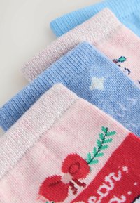 Four pairs of socks in varying colors: pink, light blue, with textured, glittery cuffs. One features printed designs of bows and stars.