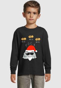 Must have piklik mustriga must t-särk, kus on joonistatud karikatuurne Jõuluvana päikeseprillides, punase mütsi ja üles kirjutatud tekst "JINGLE BELL ROCK", mille kohal on jõulukellade graafika.