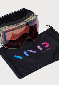 Giro slidinėjimo akiniai su žaliais ir rožiniais taškeliais ant rėmo, tamsiai raudonu objektyvu ir juodu mikropluošto maišeliu, kuriame yra daugiaspalvis „VIVID“ logotipas.