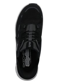 Chaussure de sport noire avec tige en maille, lacets élastiques et languette rembourrée. Présente des accents gris et une semelle blanche avec des détails texturés.