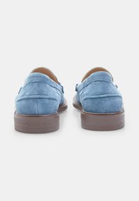 Zili zili zamšētu loafers ar zemu brūnu gumijas zoli, nedaudz papēdi un izstrādātām šuvēm gar malām.