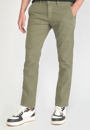 Pantalones verde oliva con corte slim, fabricados en una mezcla de algodón. Cuentan con bolsillos frontales, trabillas para cinturón y una textura suave.