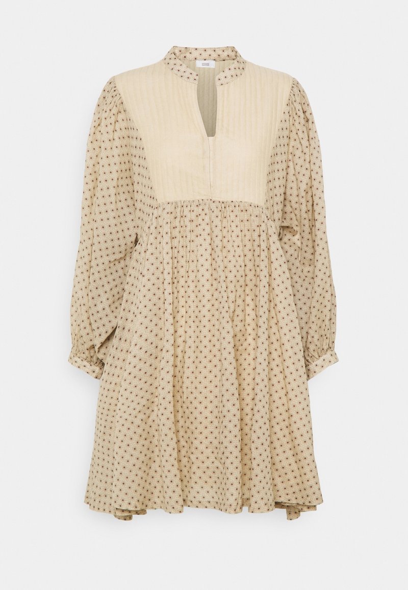 Robe longue beige à manches longues avec petits pois marron, panneau côtelé sur la poitrine et col montant avec ouverture fendue à l'avant.