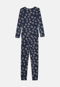 Ensemble de pyjama bleu marine comportant un haut à manches longues et un col rond, ainsi qu'un pantalon, tous deux ornés de motifs de visages souriants blancs.