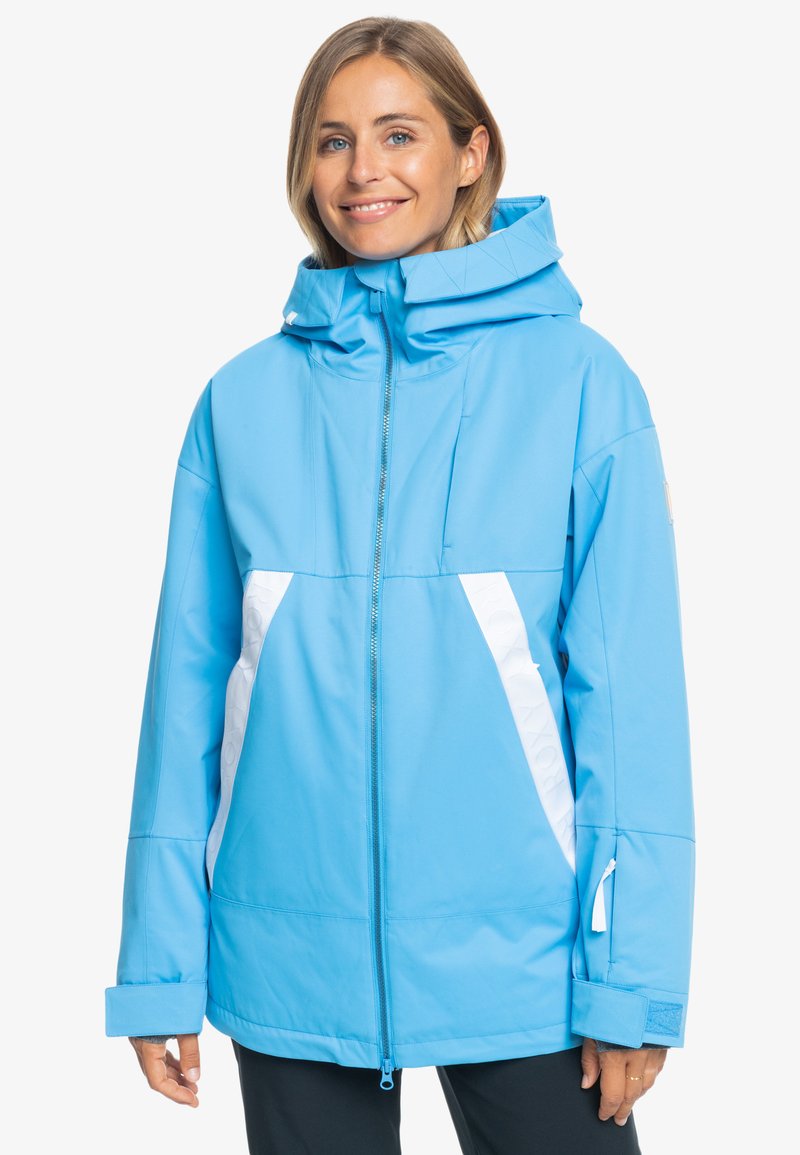Hellblaues, wasserdichtes Jacket mit hohem Kragen, durchgehendem Reißverschluss und weißen Akzenten an den Seiten. Mit Kapuze und verstellbaren Bündchen.