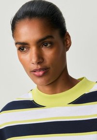 Stripet sweatshirt med en ribbet gul krave, prydet med marineblå, hvid og grønne striber. Glat stofstruktur og afslappet design.