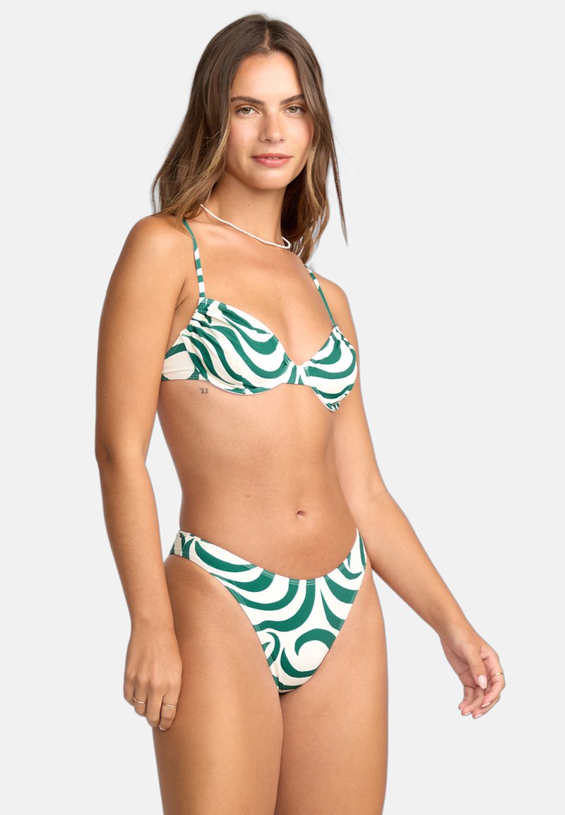 Bikinitrupp med ett grönt och vitt vågmönster, tillverkad av elastiskt tyg. Toppen har justerbara remmar och en kupa design.