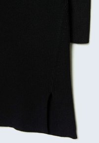 Robe en tricot côtelé noire avec fente sur le côté, manches longues et finition texturée. Design simple avec une silhouette ajustée.