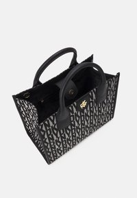 Czarna i szara torba tote w wzory, z dwoma czarnymi uchwytami, złotym akcentem logo, otwartą górą i wyraźnie prostokątnym kształtem.