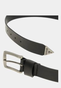 Ceinture en cuir noir avec boucle rectangulaire en argent, pointe finie avec un triangle en argent gravé "GUESS", plusieurs trous d'ajustement.