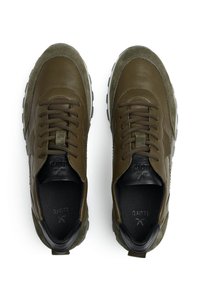 Sneaker verde oliva con materiali in pelle e camoscio, punta rotonda, suola in gomma spessa e interno nero a contrasto. Sistema di allacciatura dettagliato.