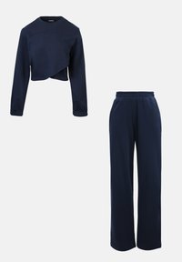 Sweatshirt cropped bleu marine à manches longues, légèrement drapé ; associé à un pantalon de jogging large bleu marine avec taille élastique. Tissu doux.