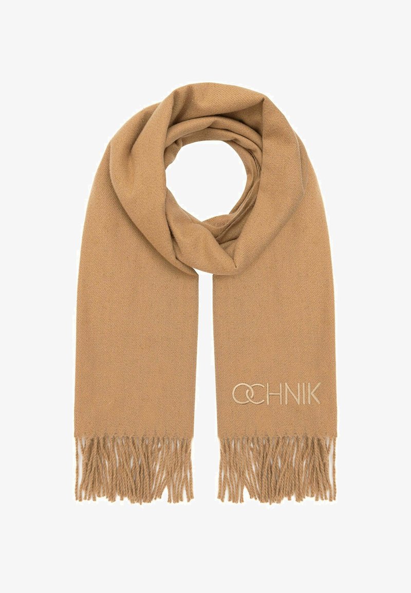 Beżowy dziany szalik z frędzlami. Wykonany z miękkiego materiału, charakteryzujący się subtelną teksturą oraz haftowanym logo blisko frędzli.