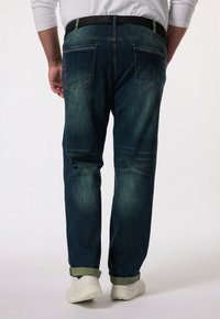 Džíny z denimu v tmavě modré barvě, s volným střihem, pěti kapsami a kontrastním prošitím. Otočený lem a černý pásek dokončují vzhled.