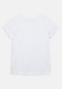Camiseta de algodón blanca con cuello redondo y mangas cortas. Textura suave, sin patrones visibles y un diseño limpio y sencillo.