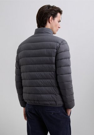 Gray puffer jacket features vertical quilted design, high collar, and elastic cuffs. Made of lightweight material, with a smooth, matte finish.
