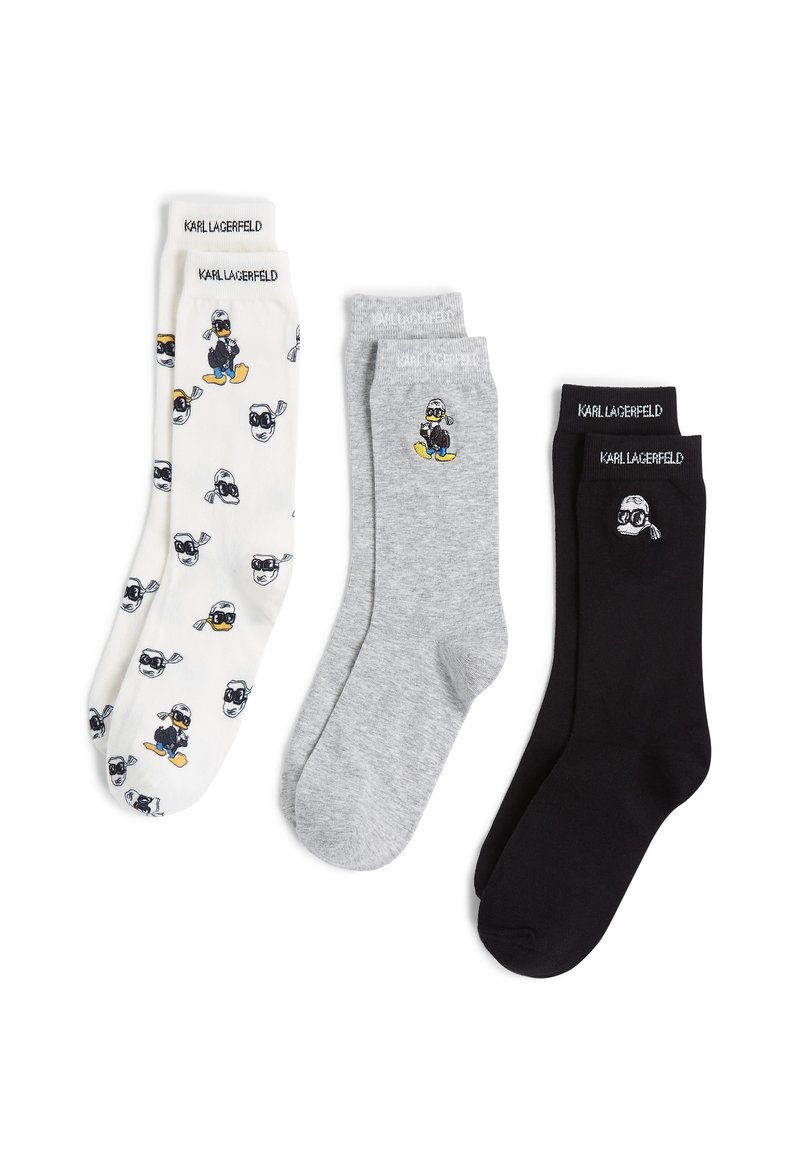 Kolme sukkaparia: valkoiset leikkisällä hahmokuviolla, harmaat pienellä hahmografiikalla ja täysin mustat, kaikissa merkkireunat.