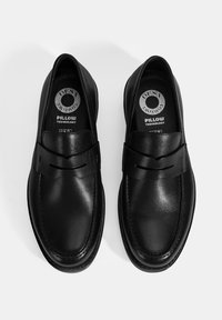 Schwarze Leder Slipper mit glatter Oberfläche, breitem Vorderriemen und gepolsterter Innensohle, mit "Pillow Technology"-Markierung im Inneren.