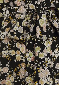 Tessuto floreale nero con piccoli fiori dai toni pastello in rosa, bianco e verde. Include un dettaglio a fiocco legato in vita.