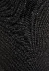 Schwarzer gerippter Stoff mit einer feinen, weichen Oberfläche, gekennzeichnet durch vertikale Linien und eine glatte Textur. Keine bemerkenswerten Muster oder Akzente.