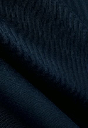 Tissu bleu marine avec une texture lisse, présentant un motif nervuré. Le matériau semble léger et flexible, adapté pour l'habillement.