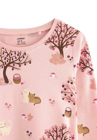 Roze kinderhemd met afgedrukte bruine bomen, paarse en roze vruchten, paddenstoelen, manden en kleine geïllustreerde katten.