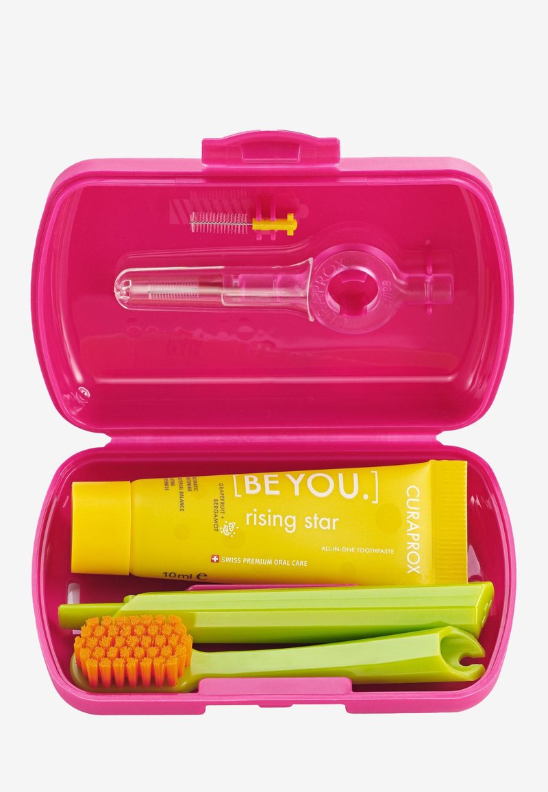 Étui de soins dentaires rose contenant un tube de dentifrice jaune, une brosse à dents verte, un porte-fil dentaire jaune et un outil de nettoyage avec des poils.