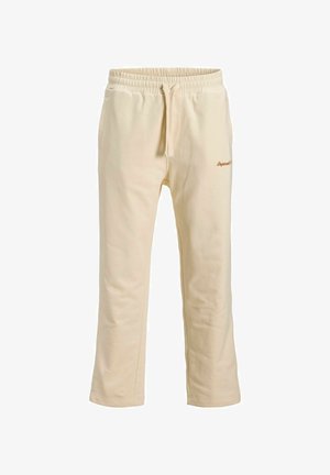 Jasnokremowe spodnie dresowe wykonane z bawełny, z elastycznym paskiem i sznurkiem, oraz bocznymi kieszeniami. Dyskretne logo jest wyszyte.