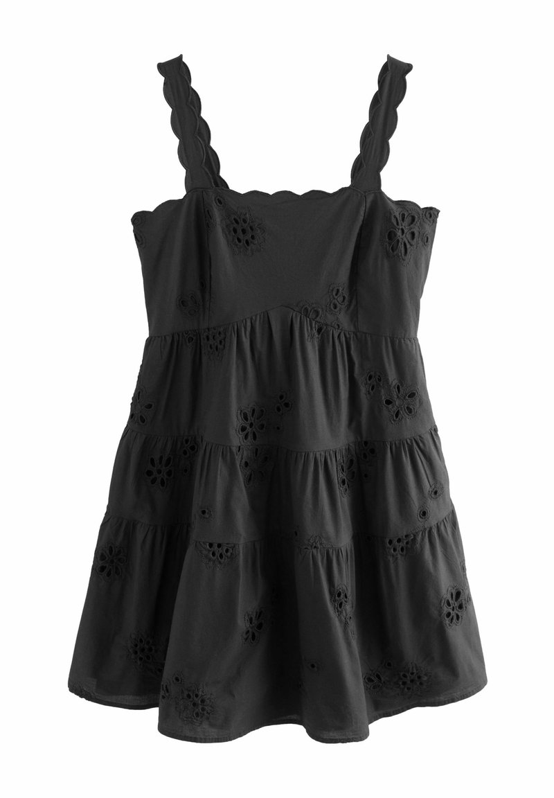 Robe noire sans manches à volants avec bretelles festonnées et détails de broderie ajourée florale.