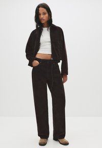 Ruskohihnainen ruskea corduroy-lyhyt takki ja siihen matching korkeavyötäröiset housut. Valkoisen istuvan paidan päällä. Kermaiset nilkkurit viimeistelevät asun.