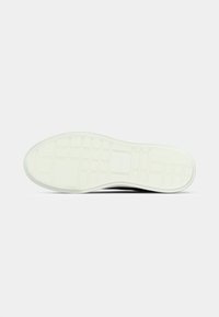 Άσπρη σόλα παπουτσιού με μοτίβο πέλματος σε μορφή πλέγματος, ελαφρώς ανυψωμένη περιοχή της φτέρνας και καθαρή επίπεδη επιφάνεια σε απλό γκρι φόντο.