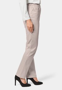 Beige broek met elastische tailleband en zijzakken, gecombineerd met zwarte hoge hakken, met een slim fit en een gladde textuur.