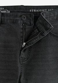 Schwarze gerade geschnittene Jeans aus Denim mit Reißverschluss, ausgestattet mit einem Knopfverschluss und dezenten Steppdetails. Glatte Textur, modernes Design.