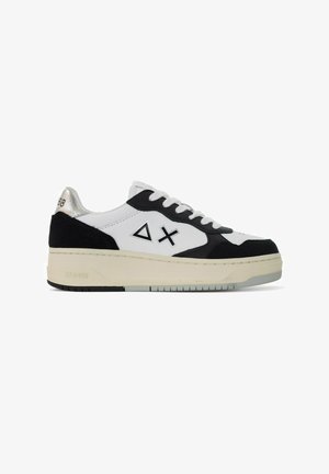 Sneakers bianchi e neri realizzati in pelle scamosciata e cuoio, con una spessa suola color crema, lacci e design del logo triangolare. Accento argentato sul tallone.
