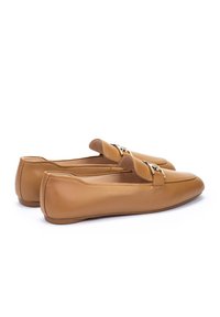 Mocassins en cuir tan avec un bout arrondi, présentant une accent en métal décoratif. Design élégant avec une texture lisse et un profil bas.