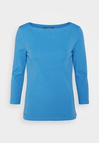 Blå långärmad t-shirt i mjukt tyg. Har en rund halsringning och en avslappnad passform. Sömmar och en liten logotyp vid nederkanten.