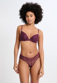 Soutien-gorge en dentelle prune et culotte hipster transparente assortie avec détails de broderie florale, bords festonnés et bretelles réglables.