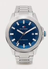 Rozsdamentes acél óra kék tárcsával, ezüst órajelzőkkel és fekete mutatókkal. Dátumablakkal és automata mechanizmussal rendelkezik.