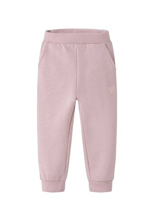 Rosa Jogginghose mit weichem Material, elastischem Bund, seitlichen Taschen und einem kleinen Herz-Detail an einem Bein.