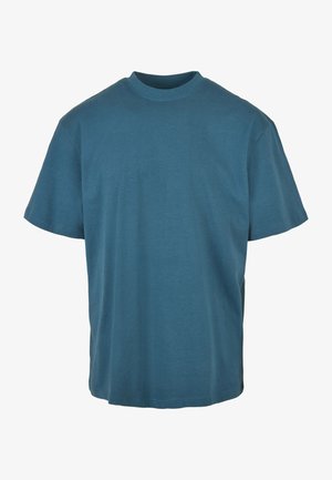 Camiseta de algodón color azul verdoso con cuello redondo y mangas cortas. Diseño simple, corte ligeramente holgado y textura suave. Sin patrones ni acentos.